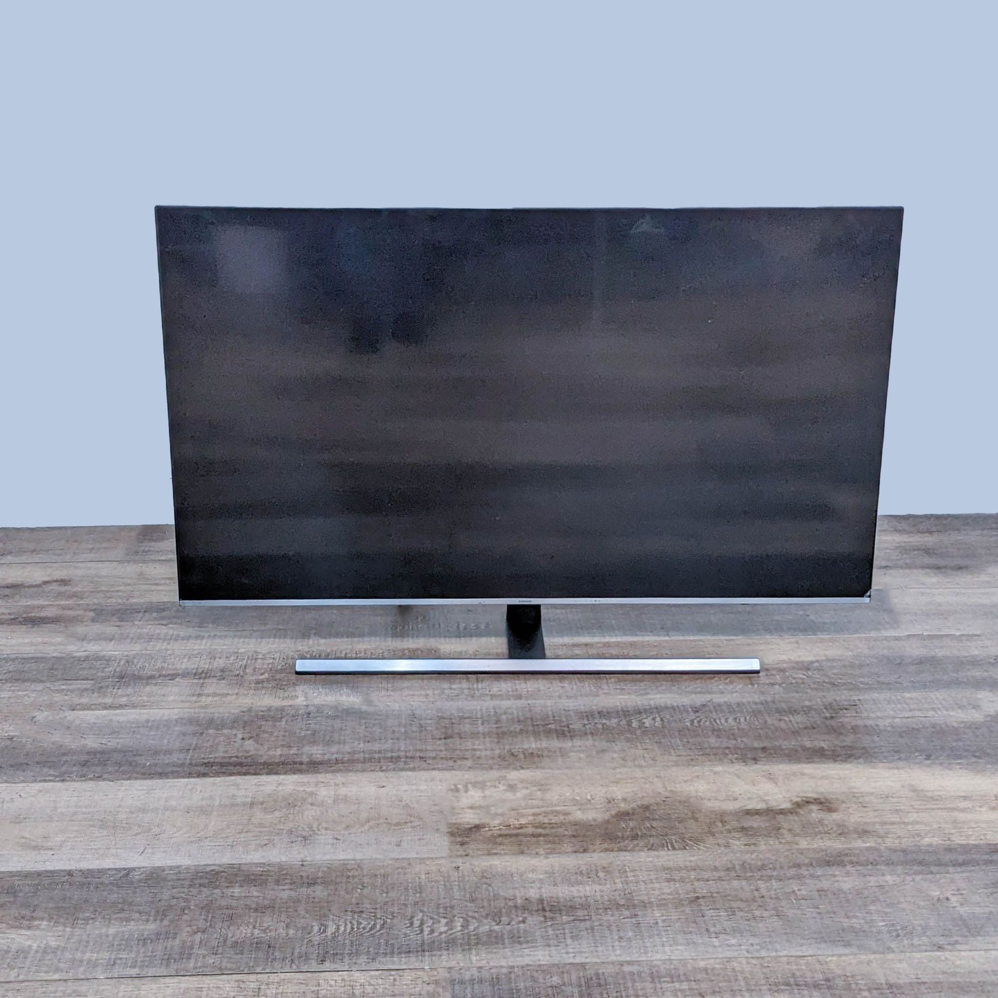Samsung UN55NU8000F edge-lit LED TV turned off, showcasing its sleek design on a wooden surface.