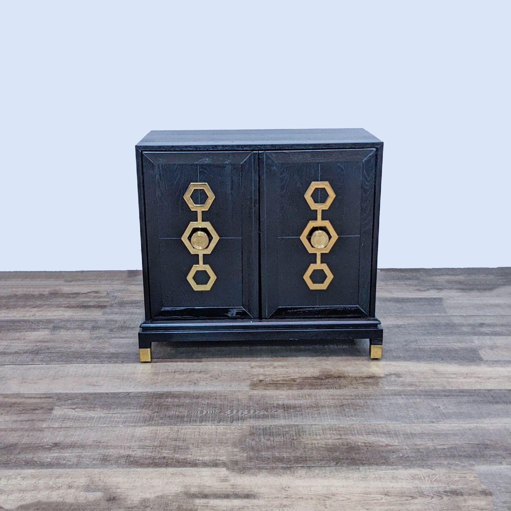 Black Johnathan Adler cabinet with antiqued brass sculpted door hardware and two adjustable shelves.
