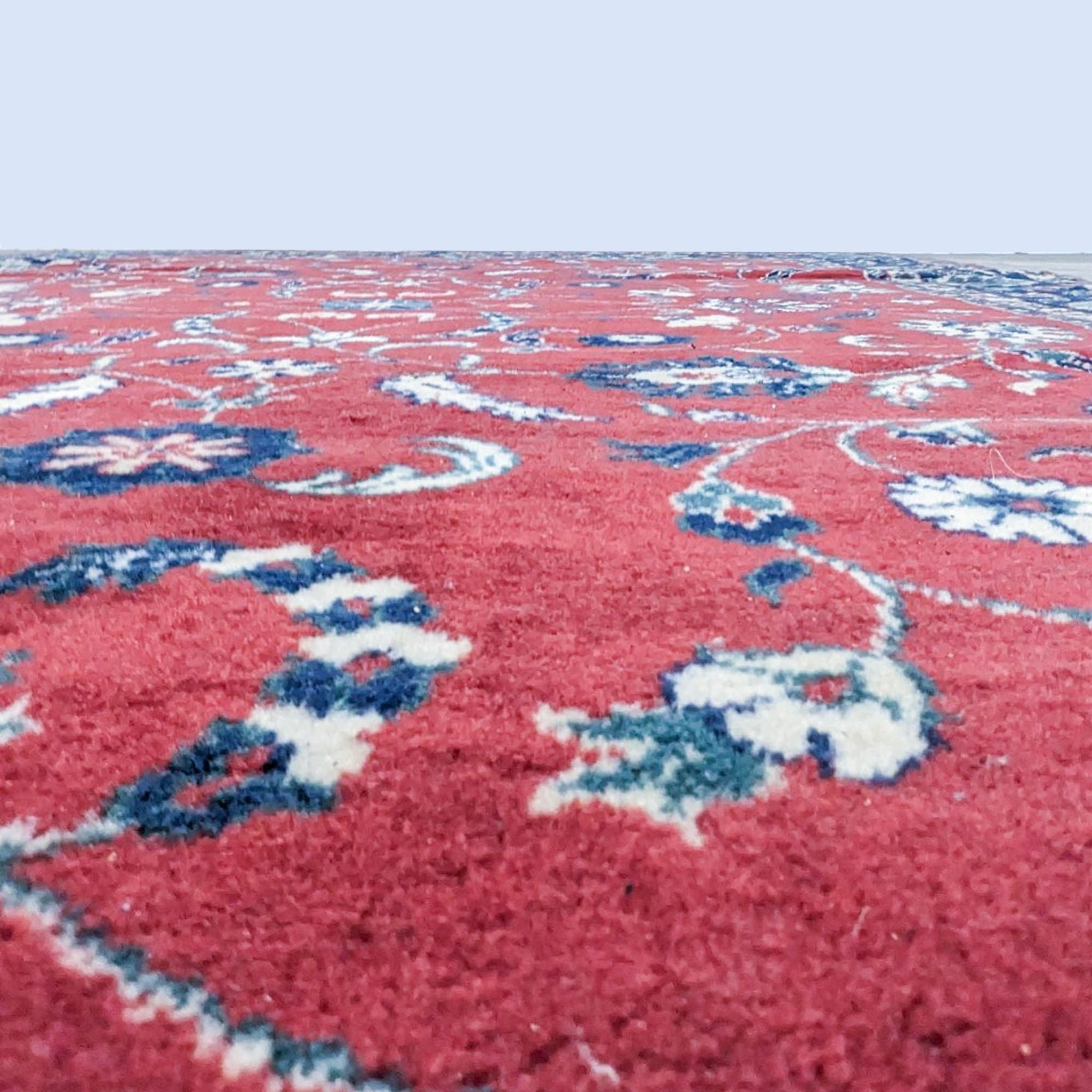 Close-up of a Reperch oriental wool rug showcasing detailed patterns and texture in vibrant red with blue and white accents.