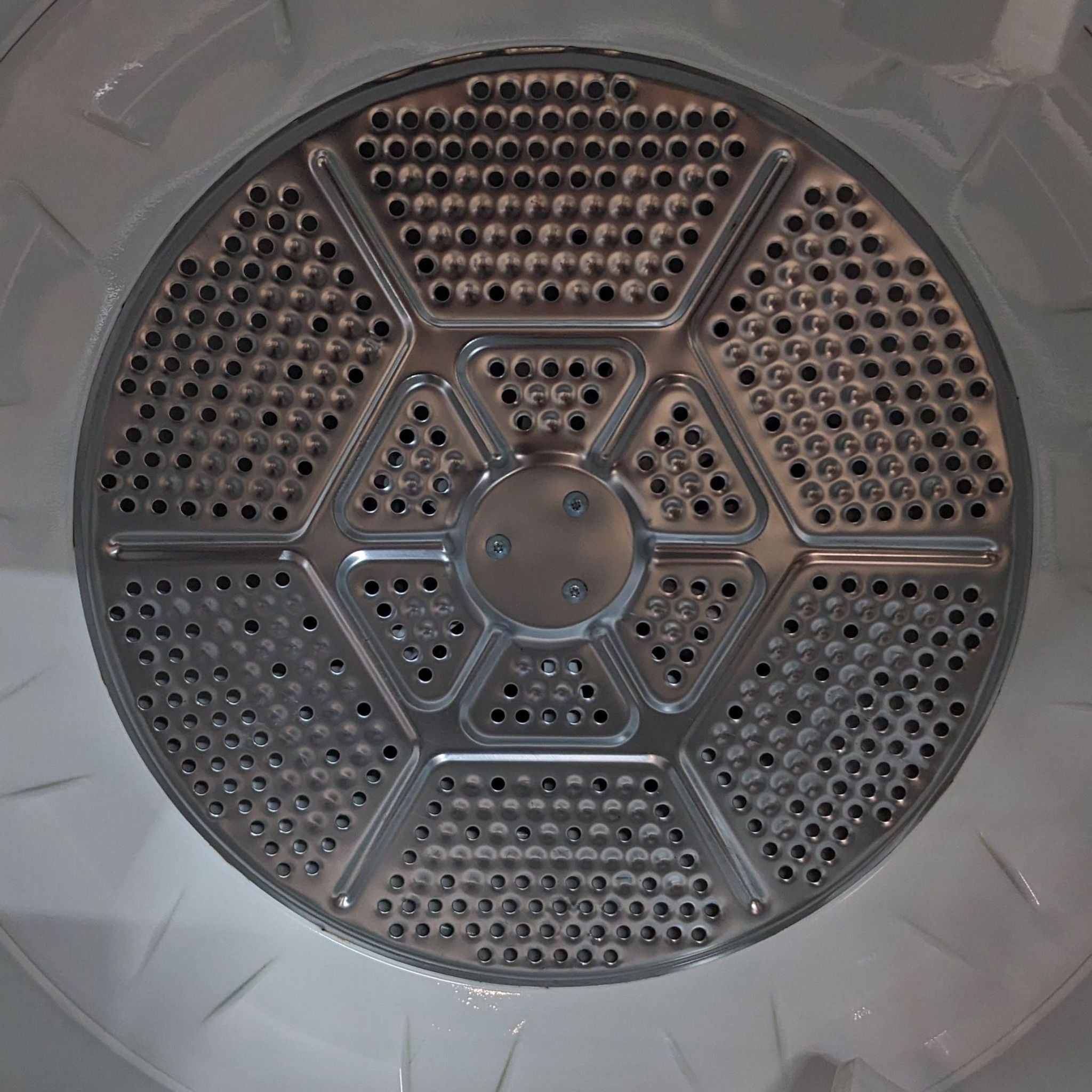 Interior view of a GE dryer drum with circular pattern and vent holes.