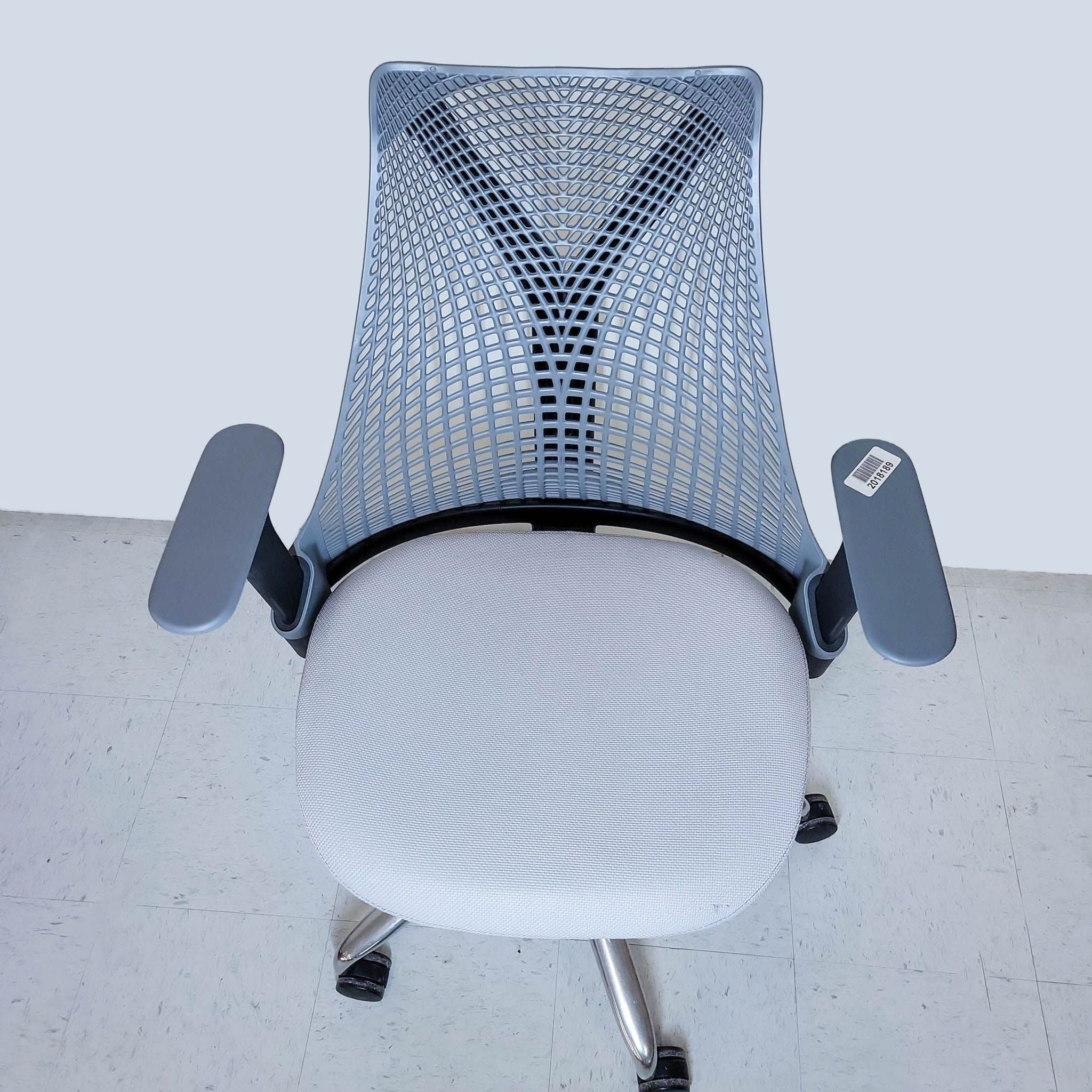 Herman Miller ergonomic office chair with mesh design, black and white, viewed from above, against a plain backdrop.