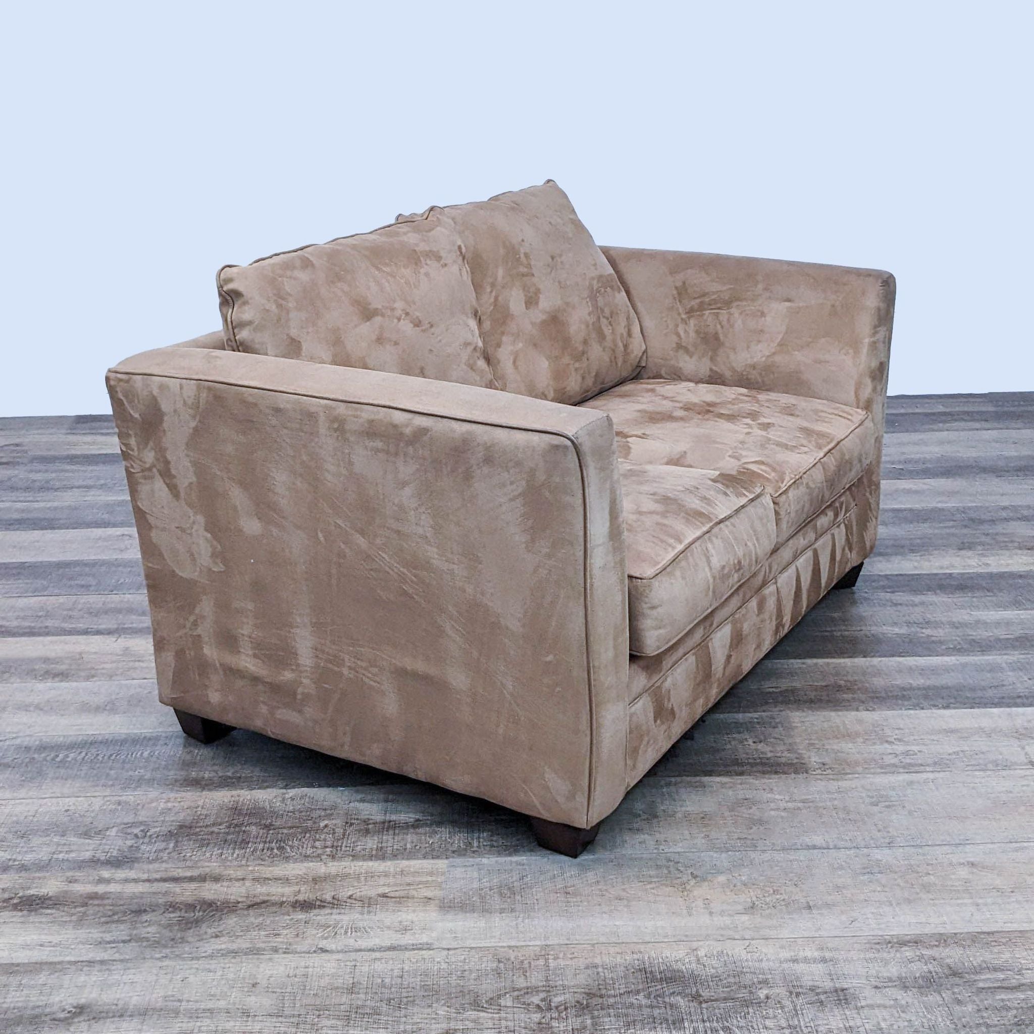 Side angle of a microfiber Reperch loveseat with a brown tone and crafted dark wooden feet.