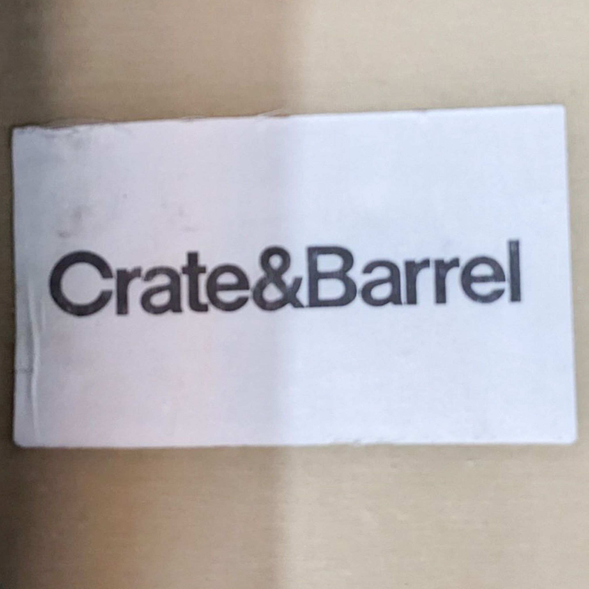 Crate & Barrel brand label on packaging, indicating the brand of a furniture item, such as a sofa.