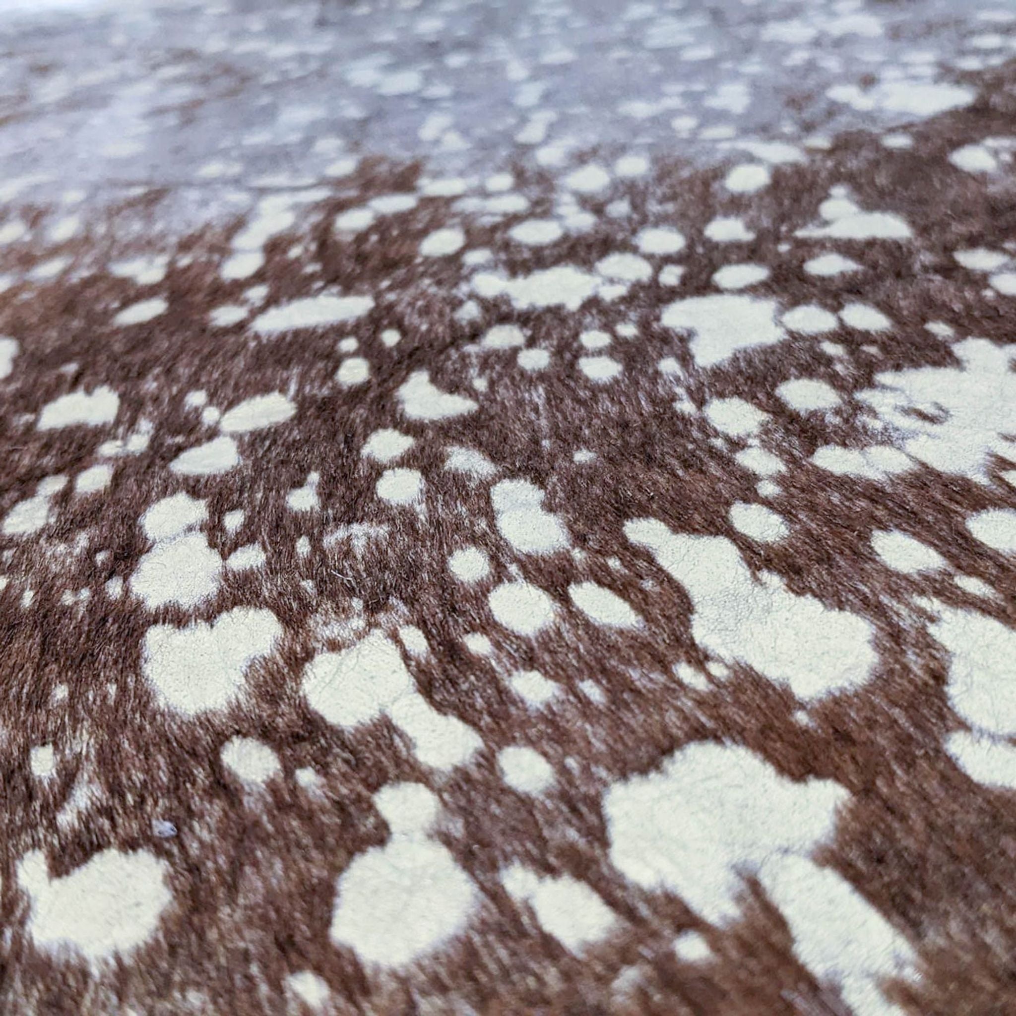 Close-up of a Reese Gold Acid Wash Cow Hide Rug showing texture and pattern.