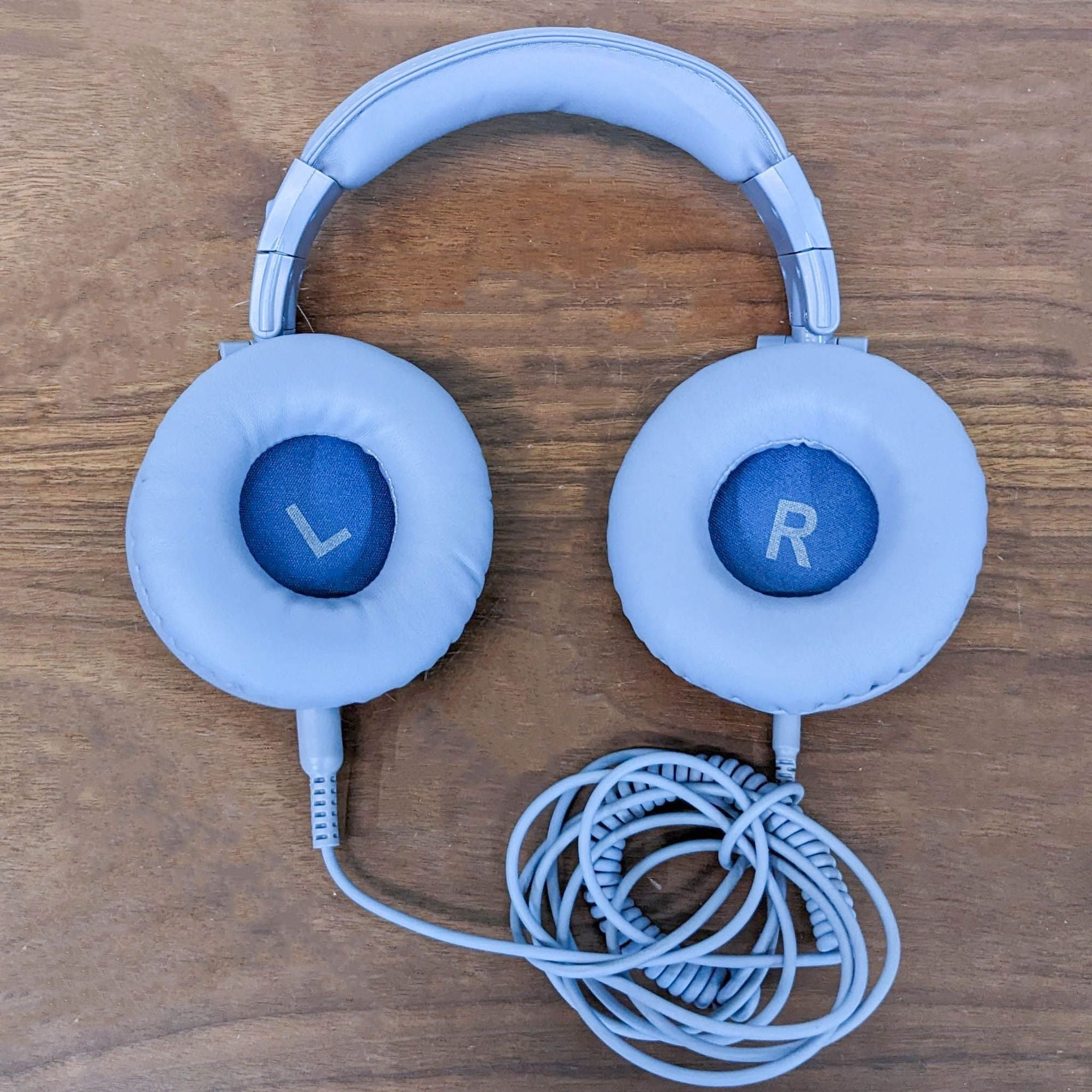 OneOdio headphones with blue "L" and "R" indicators on ear cups, highlighting intuitive design, with coiled cable.