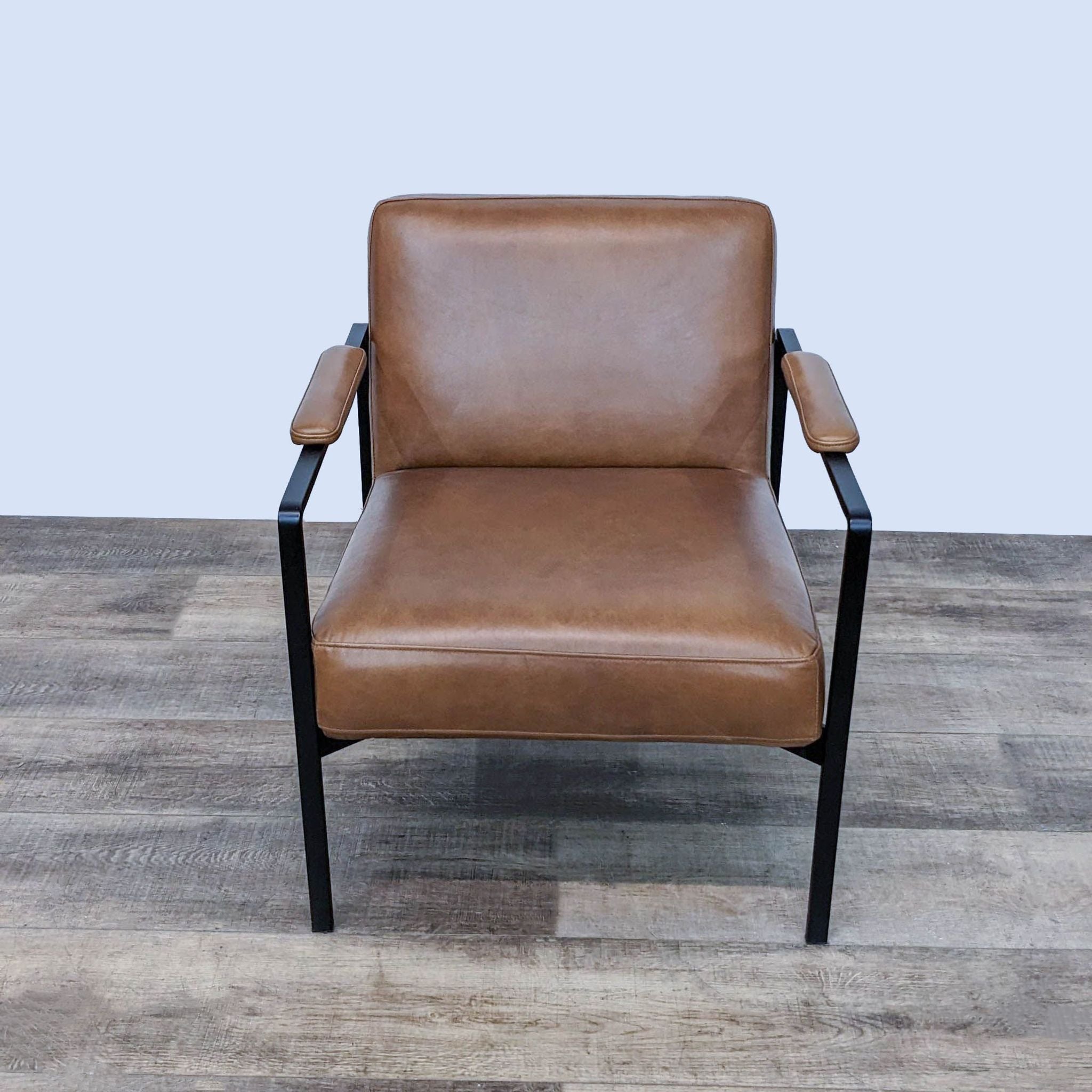 Elegant West Elm Highline lounge chair featuring cushioned leather upholstery and a sculptural steel frame, FSC-certified durable wood.