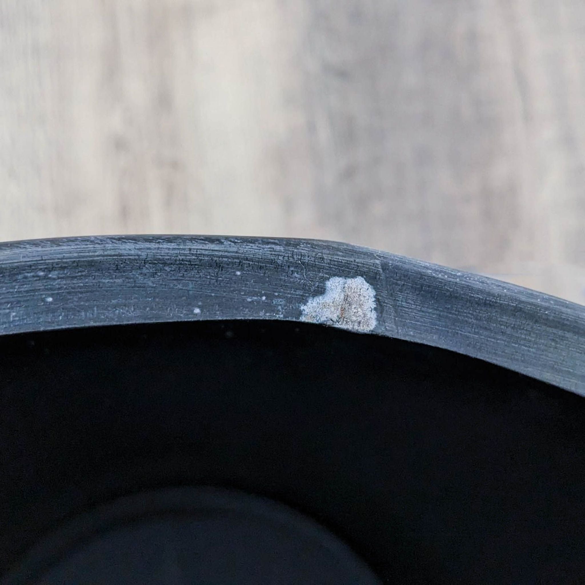 Close-up of a Reperch drum table edge showing wear and chipping paint.
