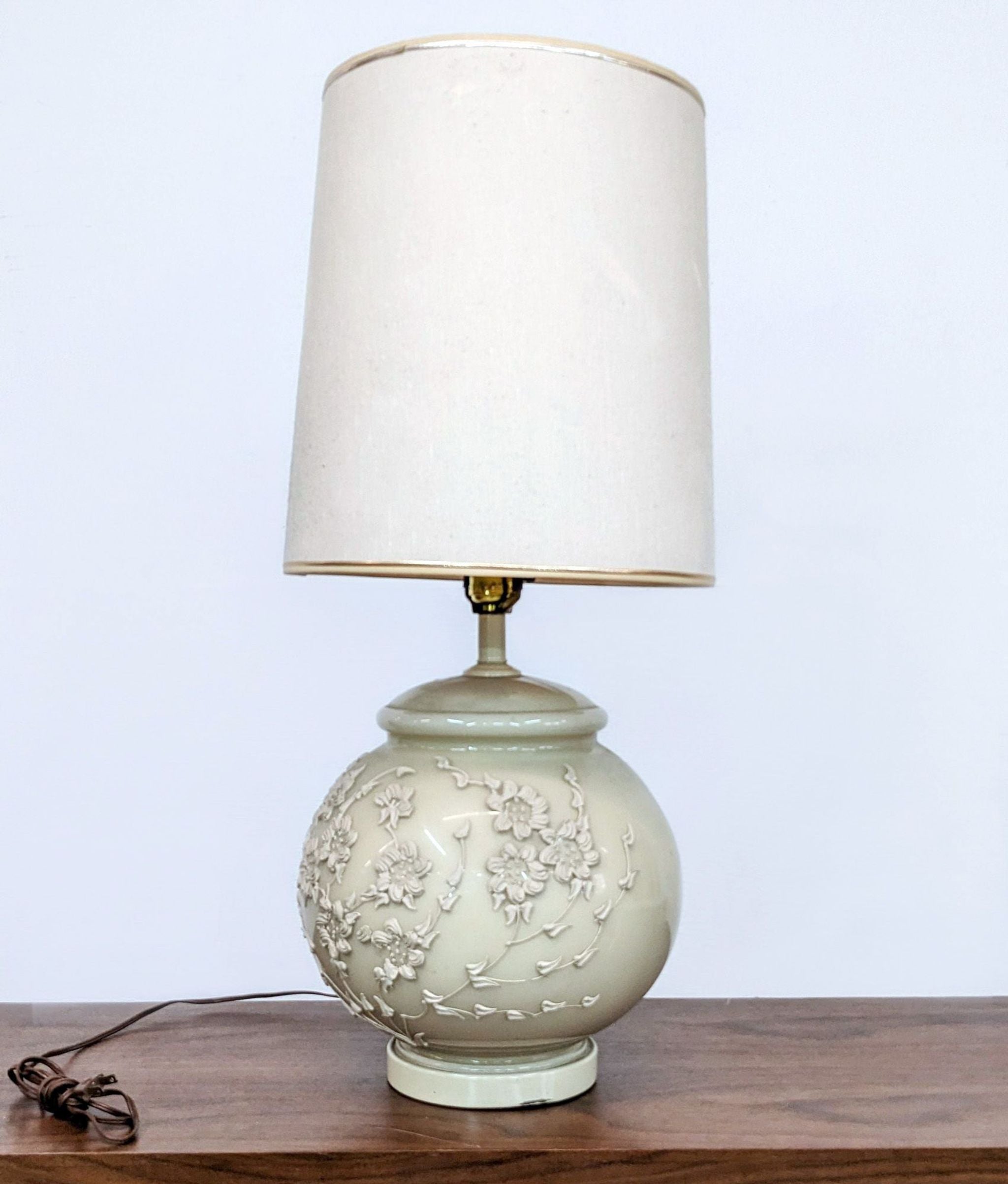 Alt text 1: Reperch brand table lamp with a cream-colored floral embossed base and a matching shade, on a wooden surface.