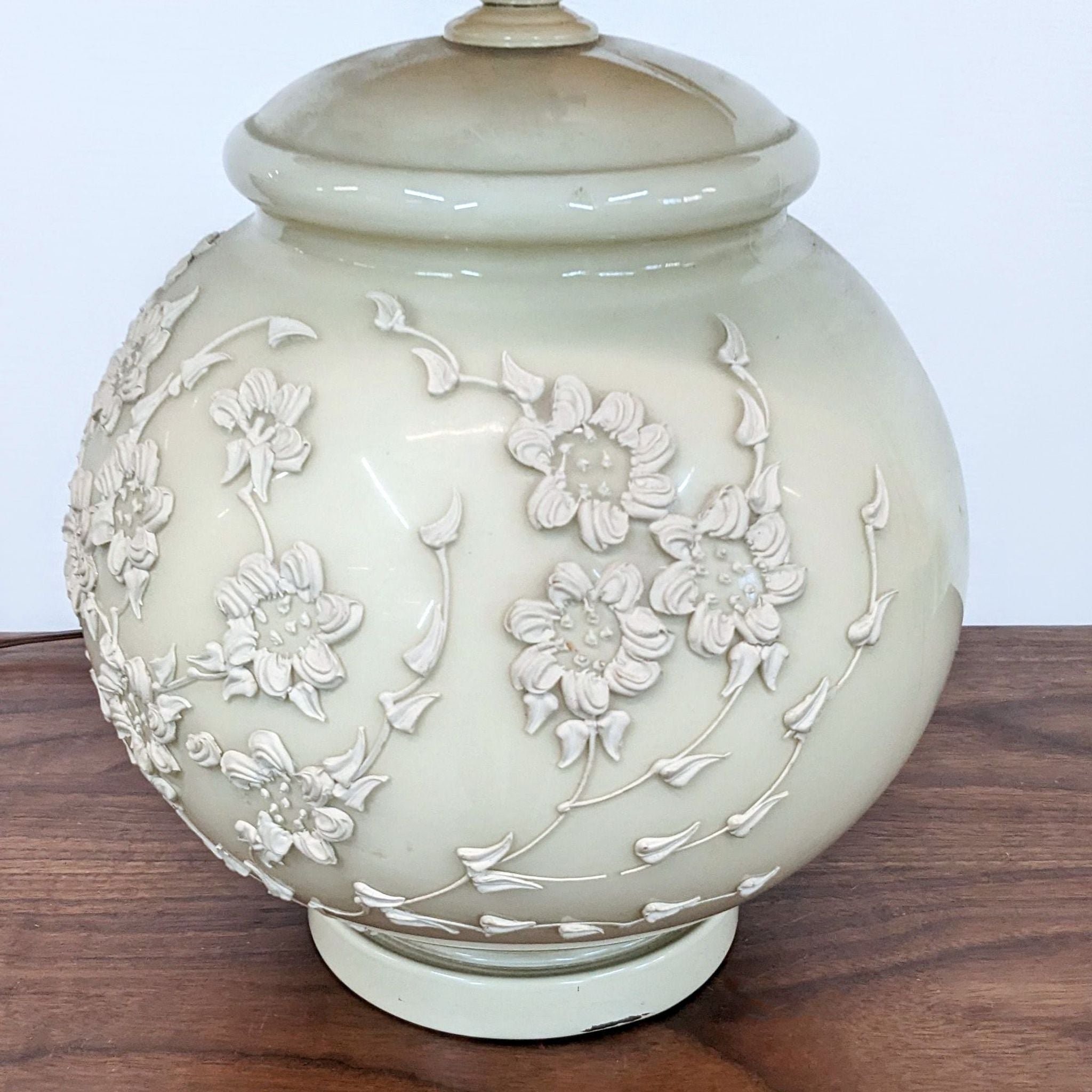 Reperch brand round ceramic lighting base with embossed floral design, showcased on a wooden surface.