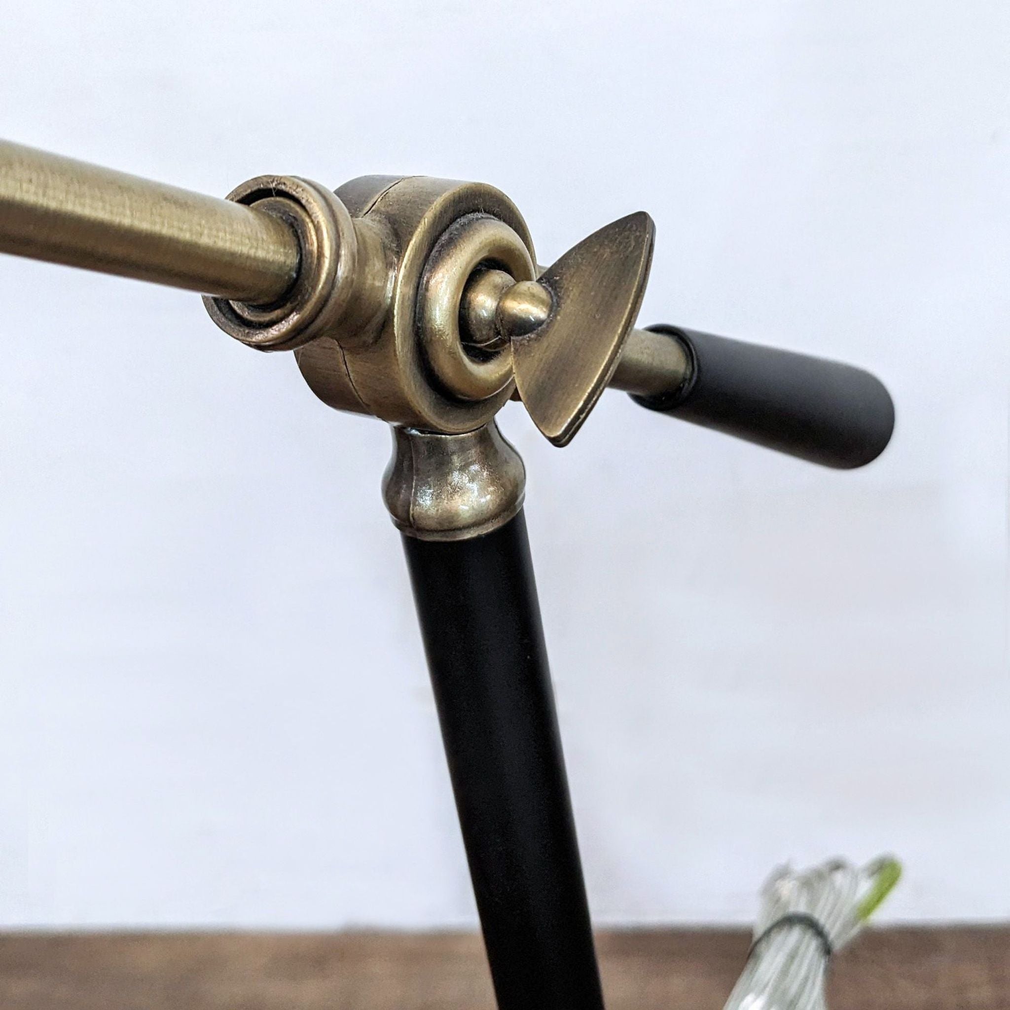 Close-up of a Reperch lighting fixture with an antique brass finish and black accents.