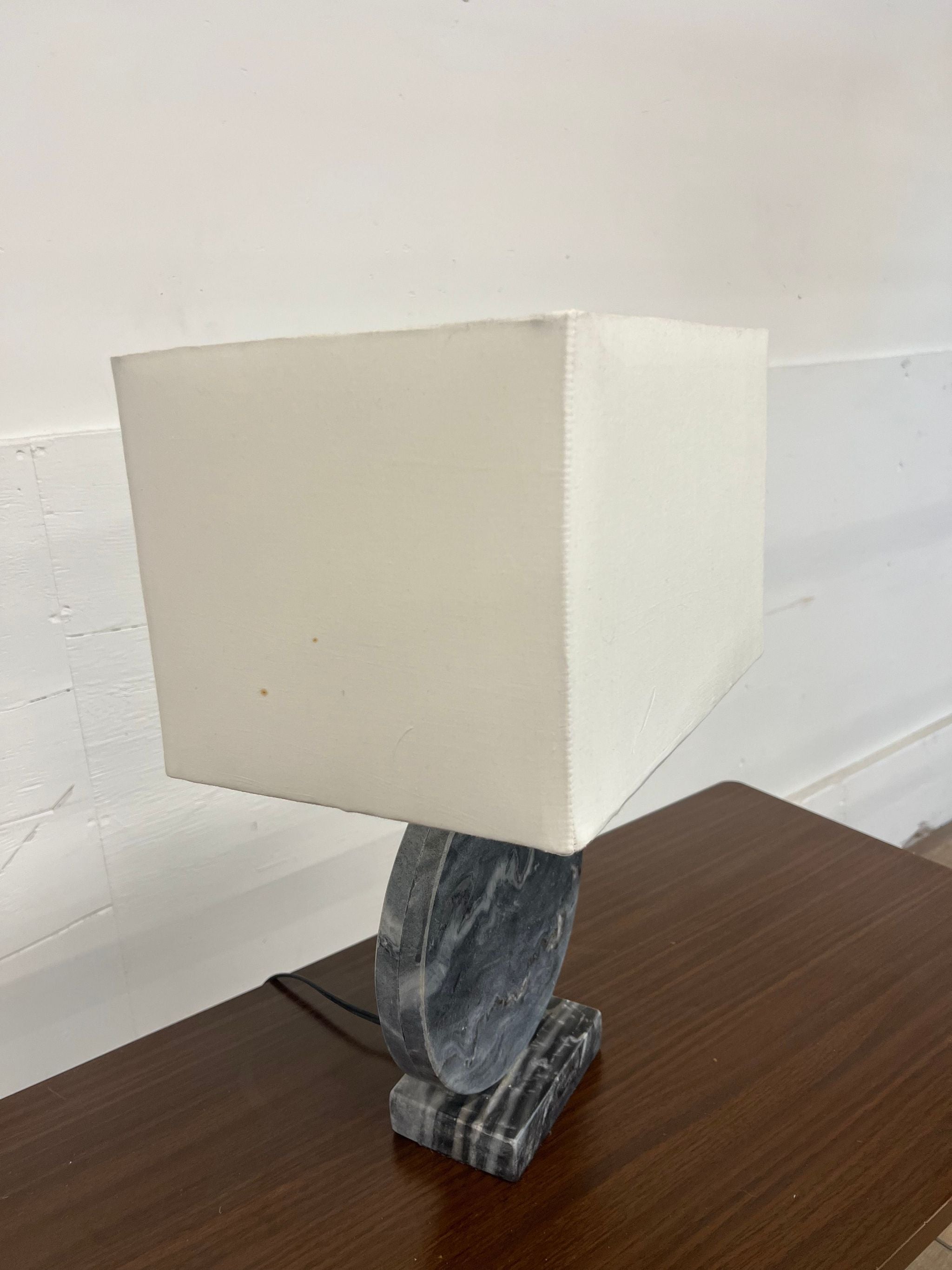 Reperch brand table lamp with a white square shade and a dark, polished marble base on a wooden surface.
