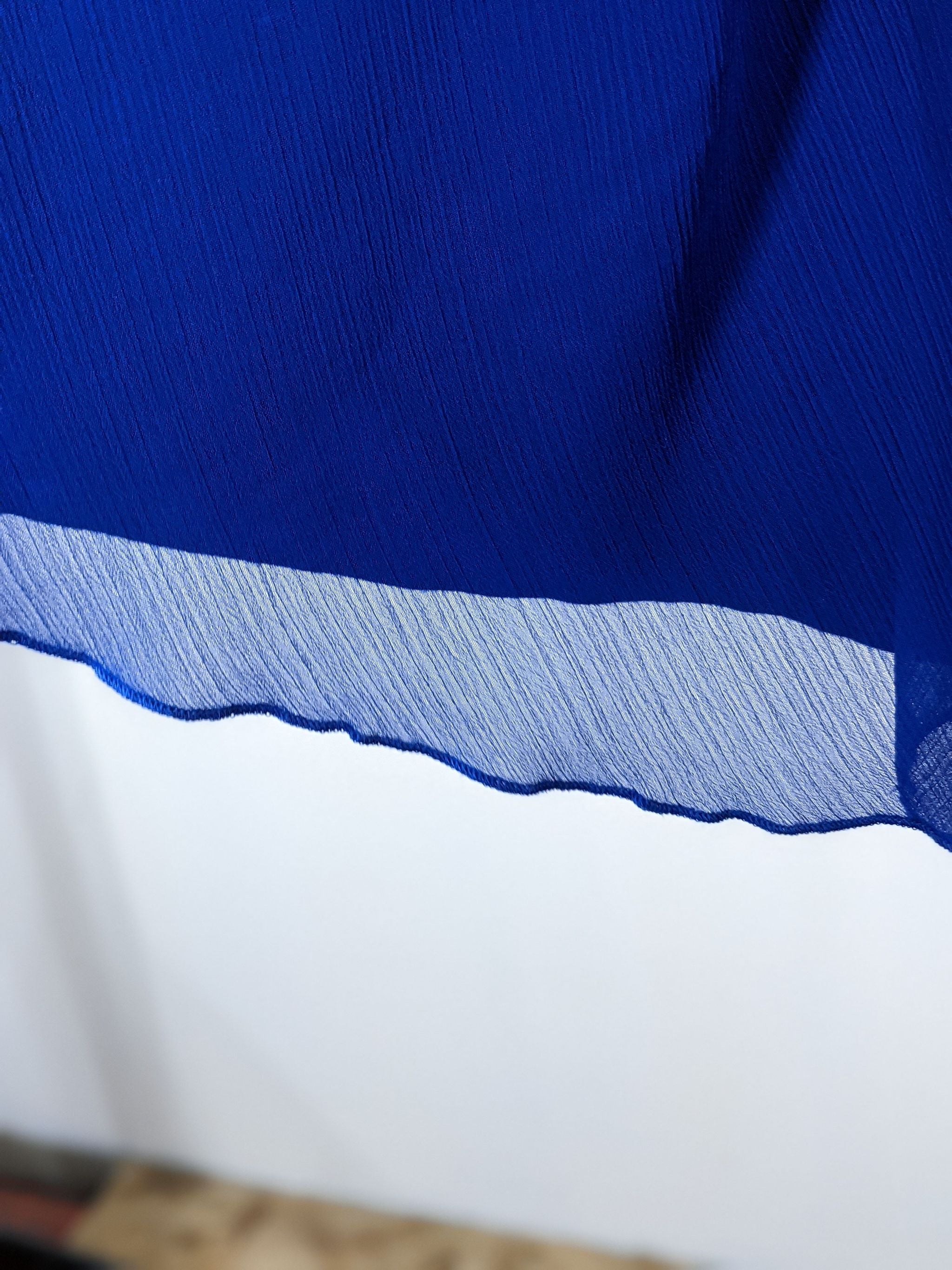 Close-up of a Chico's women's garment with blue and white color blocks and a jagged edge detail.