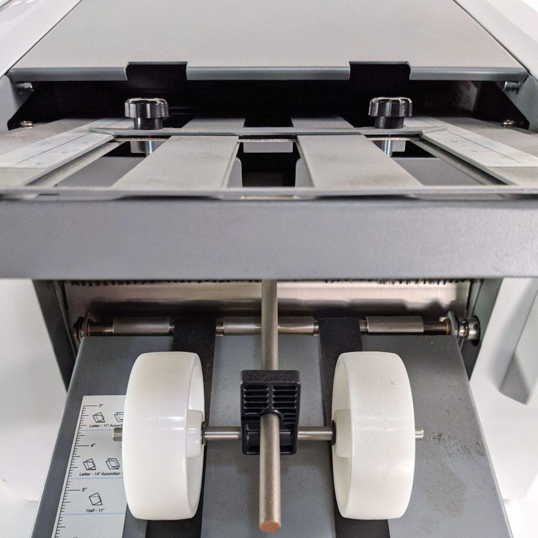 3. Close-up of the interior mechanism of a Formax printer highlighting the paper rollers and adjustable guides.