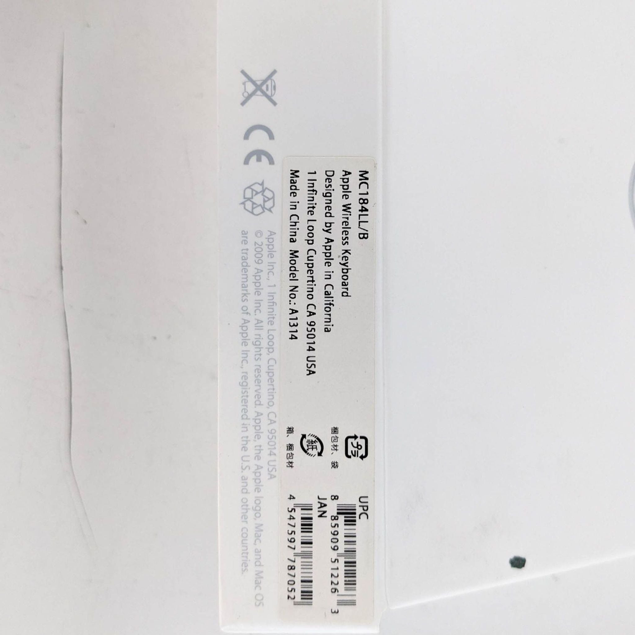 Label on an Apple product packaging with regulatory marks and a barcode, detailing product identification and compliance.
