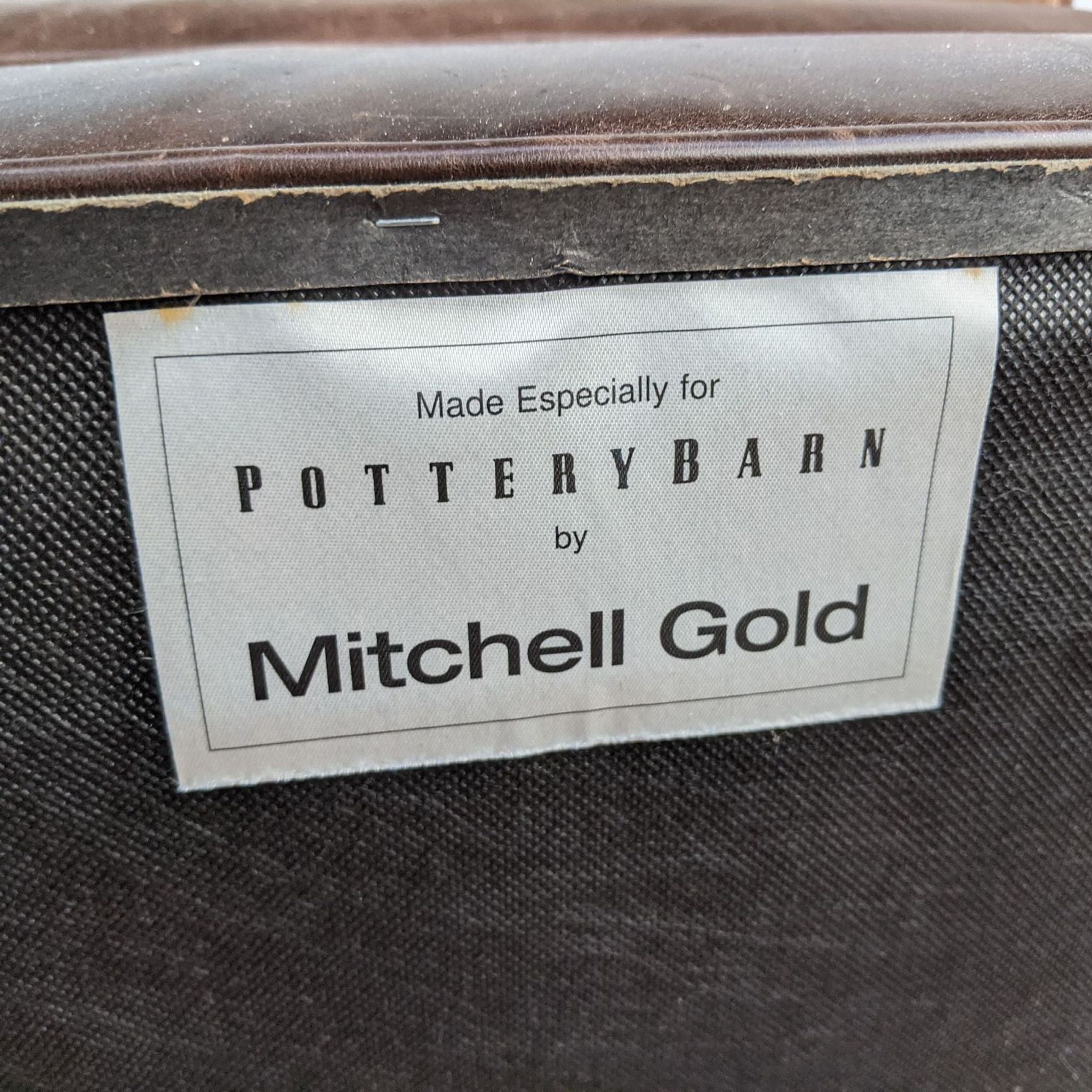 Label on furniture stating "Made especially for POTTERYBARN by Mitchell Gold" indicating brand and manufacturer.