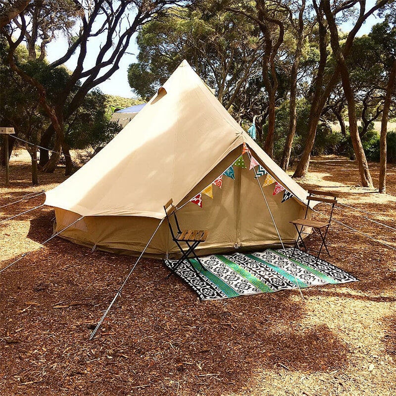 bell tent 4m in a campsite with chairs and a rug in front