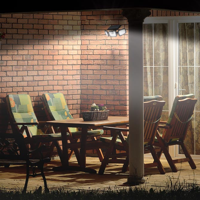 Cozy patio scene at night with a wooden table and chairs, and warm lighting.