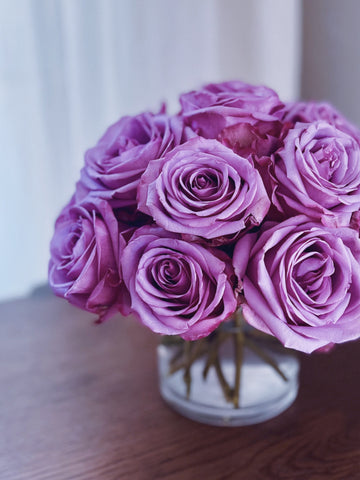A pavé vase arrangement of purple roses
