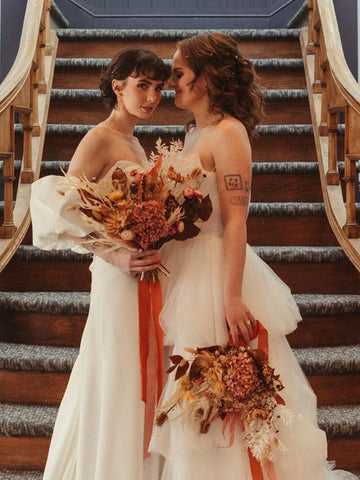 Two brides holding dried flower bouquets