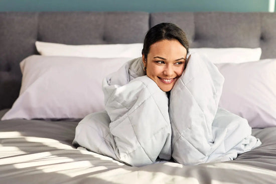 Woman in bed wrapped in Emma Hug Weighted Blanke