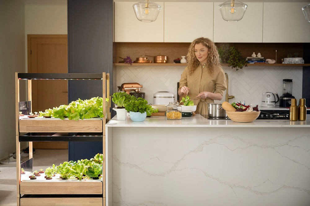 Woman preparing a meal whilst looking at the Click and Grow 25.