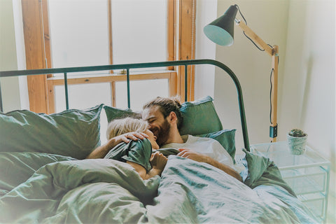 Couple dans un lit en étreinte via Unsplash