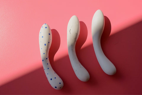 Three versions of the Dalia porcelain G-spot dildo by Désirables on pink background