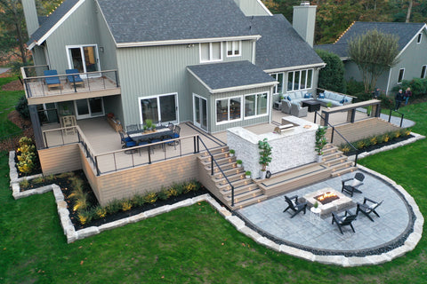 Large Outdoor living space with a multi-level wrap-around deck with outdoor kitchen and fire place