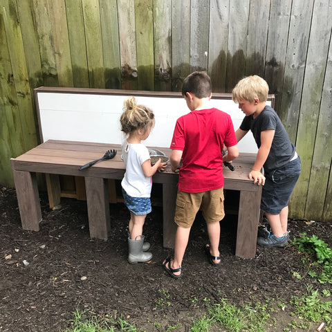 Kids playing outside with play kitchen