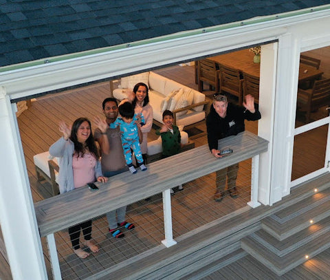 Family and contractor on Deckorators deck waving