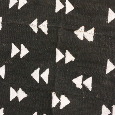 Black mudcloth textile with double arrows.