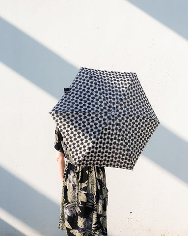 Women hiding behind black umbrella