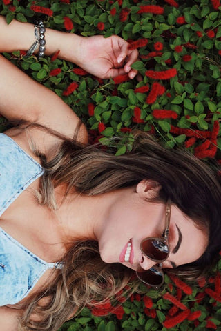 girl laying on flowers with sunglasses on