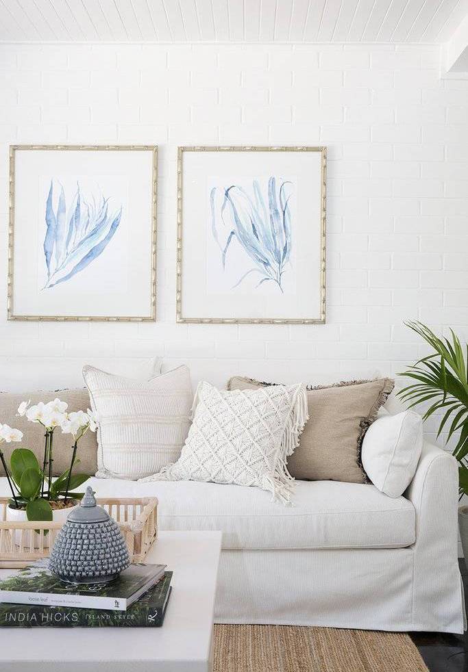 Hampton style living room with white couch and blue coral wall art prints by kerri shipp driftwood interiors
