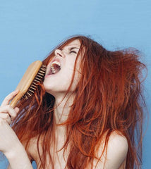 femme qui crie car elle a des noeuds dans les cheveux