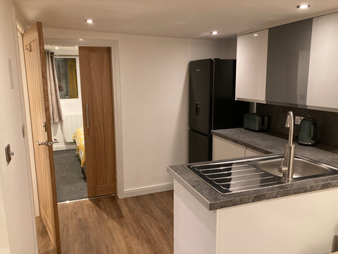 Garden office interior with dividing wall, kitchenette and oak door