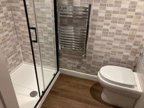A fully fitted shower room and toilet in a garden office