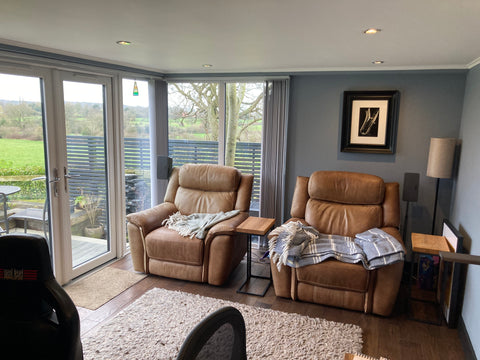 A lounge area in a garden office extension with comfortable chairs