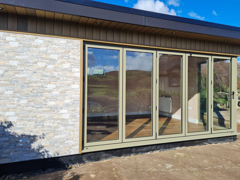Garden room with stone exterior cladding and bifold doors