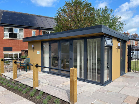 A garden room office with paving and timber balustrade