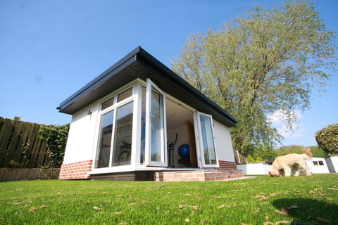 A garden room office in Preston, Lancashire with a rendered exterior and brick plinth