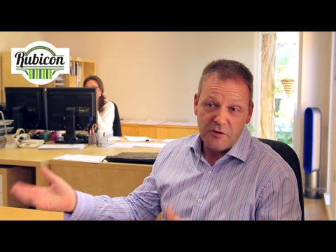 A man in an office talking to a woman.