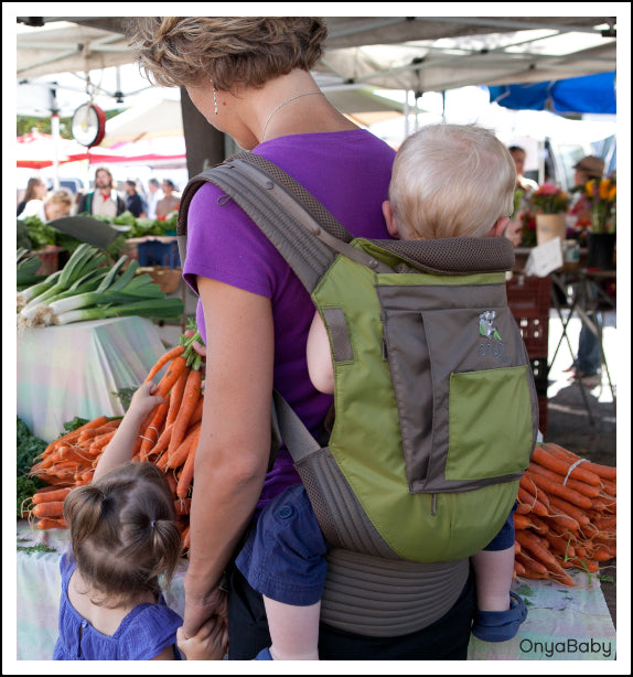 Mother babywearing and shopping for food