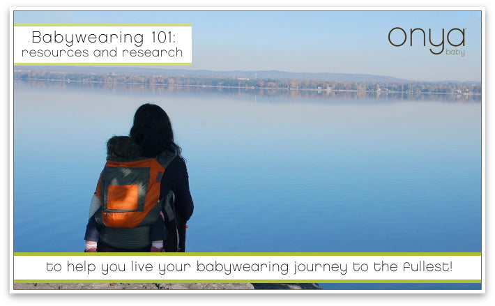 Mother wearing child in an Onya Baby Carrier overlooking a lake