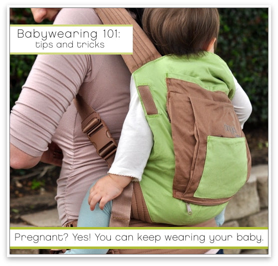 Pregnant mother demonstrating back carry with an Onya Baby Carrier