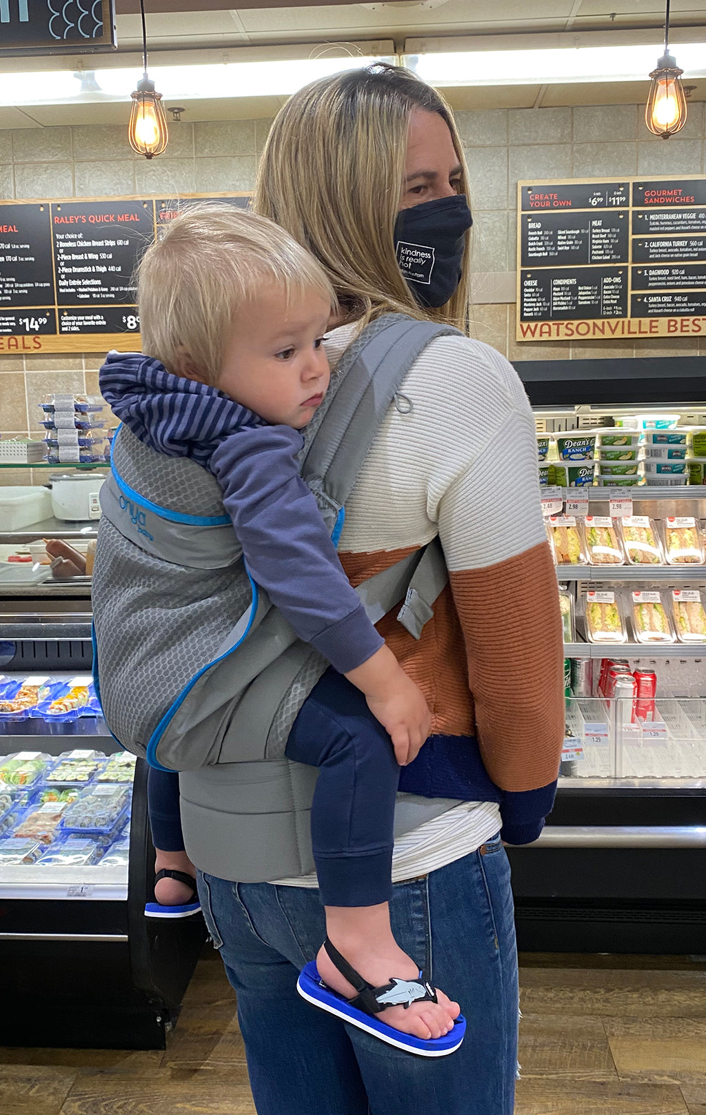 Parent grocery shopping with baby in Onya Carrier