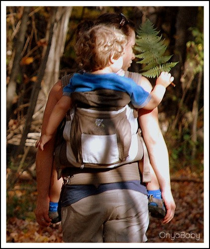 Parent hiking while babywearing with an Onya Baby Carrier