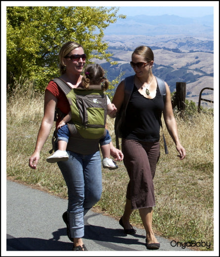Parents out for a walk with child in an Onya Baby Carrier