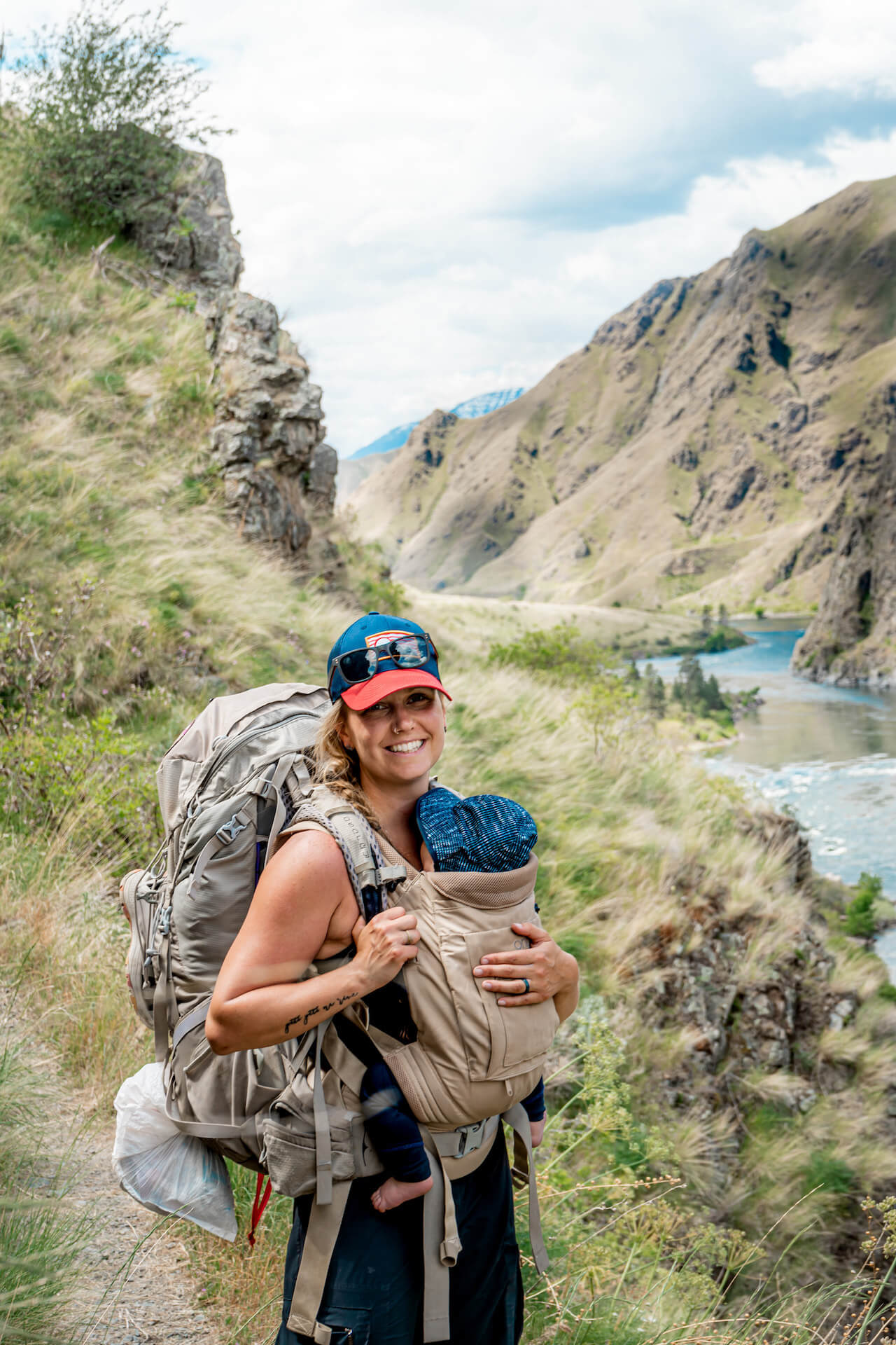 Mother on hiking path with baby smiling in Onya Baby carrier