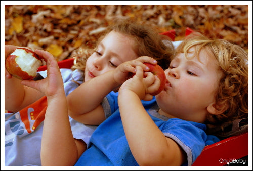 Happy children eating apples on a wagon